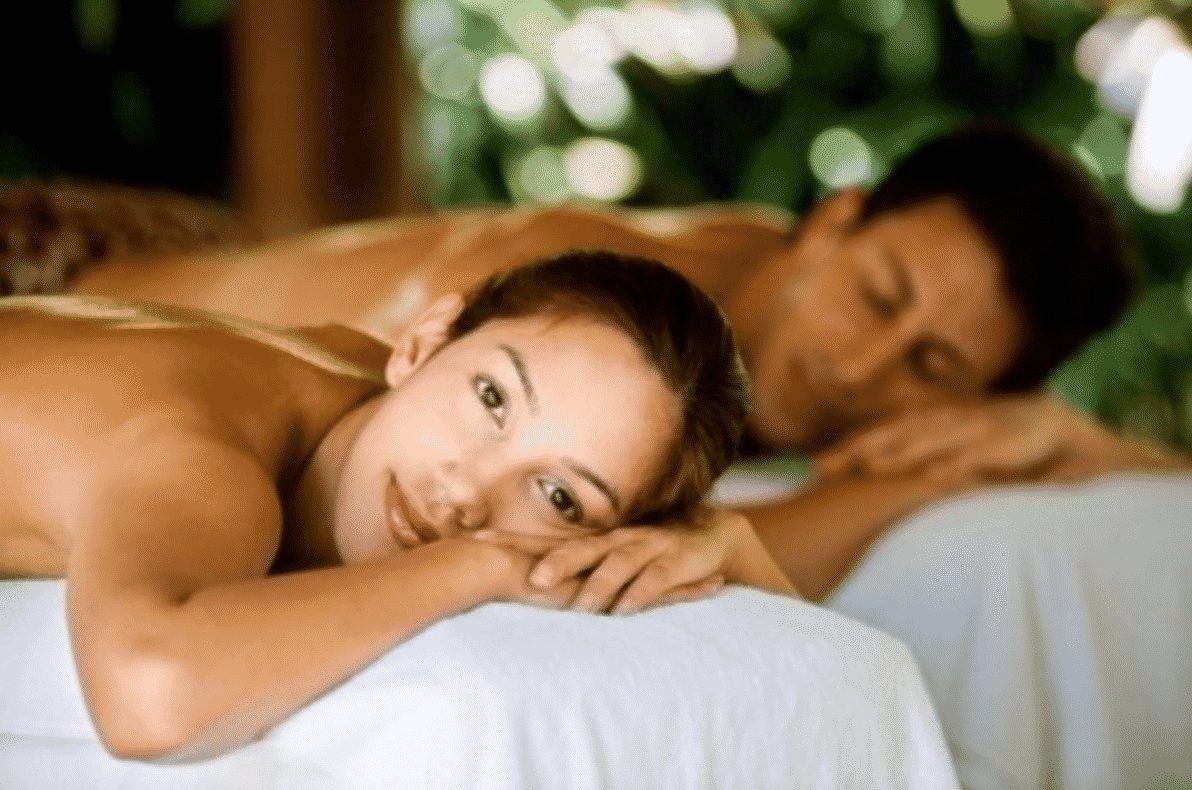 A couple relaxing side by side on massage tables