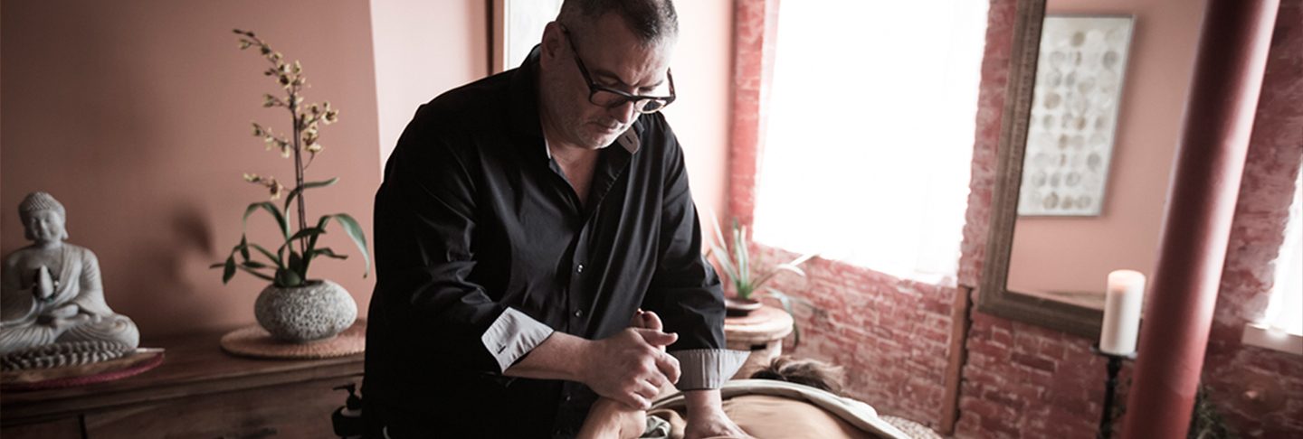 Rod Cain giving a deep tissue massage in his brick-walled Burlington studio
